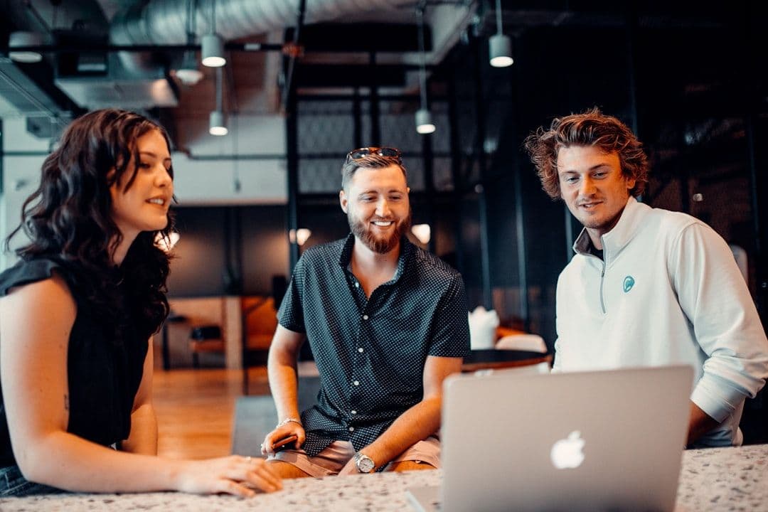 Three developers collaborating on custom business software development for large enterprises