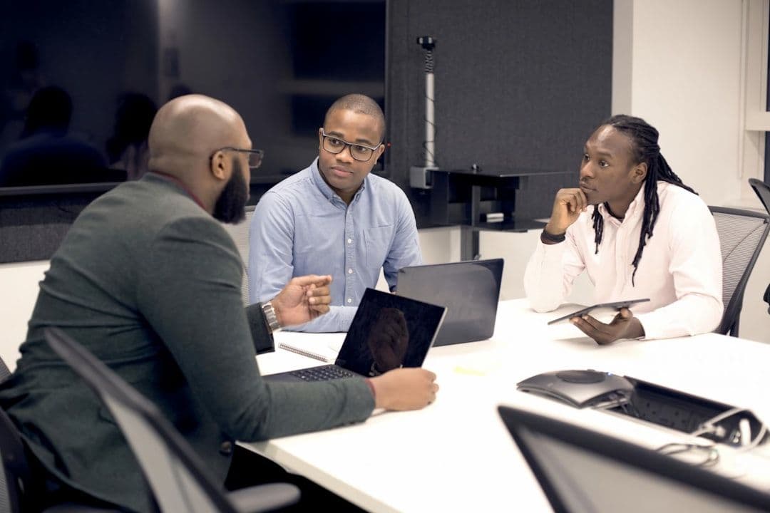 Three developers collaborating on custom business software development for large enterprises