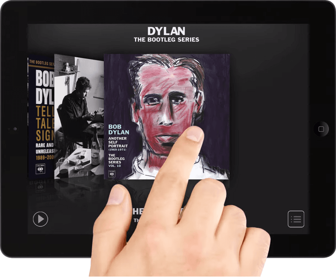 A hand swiping on a tablet through a carousel of images of Bob Dylan's album covers on Bob Dylan's The Bootleg Series app..