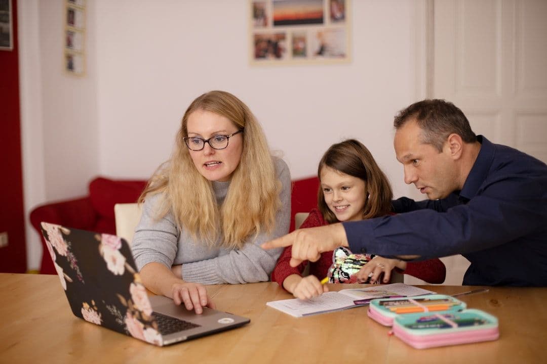 Parent using school management software on laptop to access communication tools.