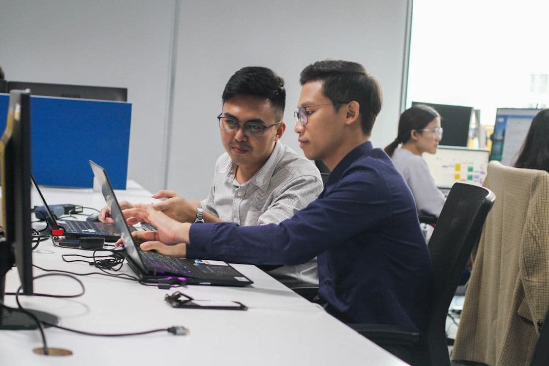 Two individuals brainstorming on a laptop for E-Learning Platform Development
