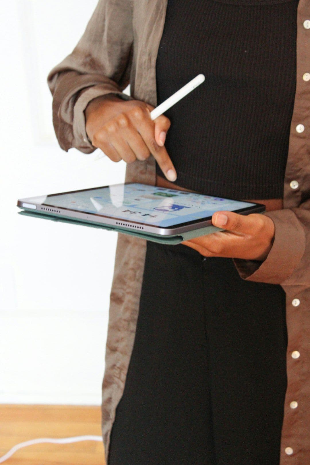 Close-up of a hand holding a smartphone displaying training organizations' courses on a mobile app.